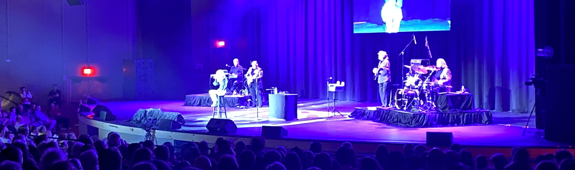 signer on stage in chair washed out by the lights Pittsburgh